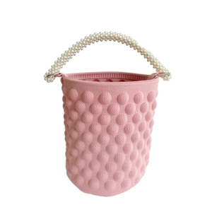 Pink knit bucket bag with bubble texture and elegant faux pearl beaded handle