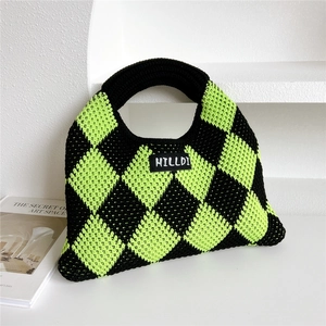 Detailed knit texture of green and black checkered pattern on a handmade handbag