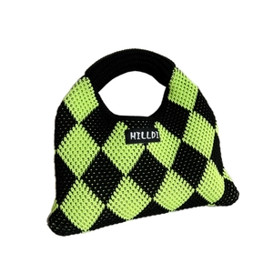 Knitted handbag featuring green and black checkerboard pattern with woven handles