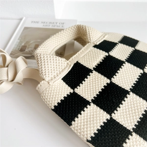 Détail du sac cabas en maille à damier noir et blanc avec texture tissée épaisse et poignée