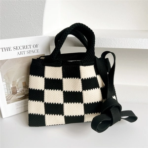 Détail de la texture tricotée d'un sac cabas à damier noir et blanc avec fermeture