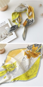 Macro detail of pleated silk scarf with floral pattern in yellow, grey and white