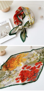 Detail of red floral pleated scarf with wave edges and elegant accordion fold texture