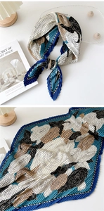 Detail of accordion pleated floral scarf in navy and cream with fine texture