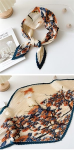 Close-up of pleated silk scarf with floral print and navy blue contrast edging detail