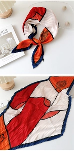 Detail of pleated silk scarf with red and orange geometric color block and fine textures