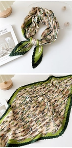 Detailed view of pleated silk scarf featuring floral prints and rich textured fabric surface