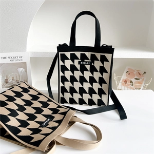 Knitted houndstooth tote bag with adjustable shoulder strap and woven black handles
