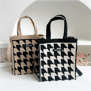 Detailed close-up showing the premium knitted texture and geometric houndstooth pattern of the tote