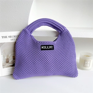 Close-up of purple knit tote bag with woven texture and a minimalist brand label