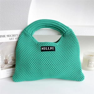 Detailed close-up of bright green knitted tote bag with textured weave and brand label