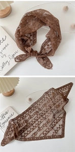 Détail d'un foulard en dentelle marron avec motifs floraux et bords festonnés