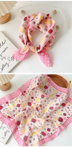 Detail of pink cotton-linen scarf featuring lucky smiley face patterns and polka dot border