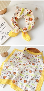 Detail of yellow cotton linen scarf featuring cartoon orange smile and LUCKYTRY print