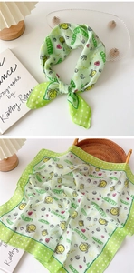 Detail of light green floral square scarf with LuckyTry text and smiley face patterns