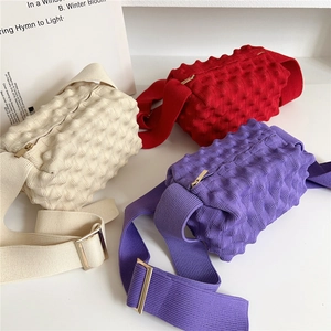 Three colorful pineapple knit crossbody bags with popcorn texture and wide straps