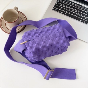 Detailed close-up of purple knit popcorn texture crossbody bag with gold zipper and wide strap