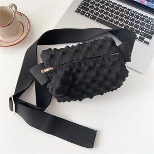 Close-up of black popcorn texture knit bag with gold zipper and adjustable wide strap