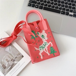 Detail of pink knitted phone bag with reindeer pattern and heart button closure