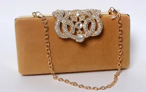 Golden velvet clutch bag with rhinestone crown ornament and fine chain strap
