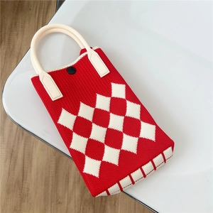 Nahaufnahme der rot-weißen Strickhandtasche mit lederverstärktem Griff und Knopf
