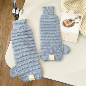 Detailansicht hellblauer Strickstulpen mit Rippbündchen und seitlichem Textiletikett