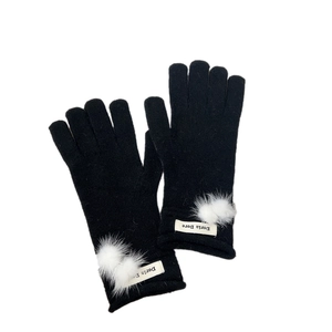 Black knit gloves with white faux fur pom-poms and minimalist woven label details