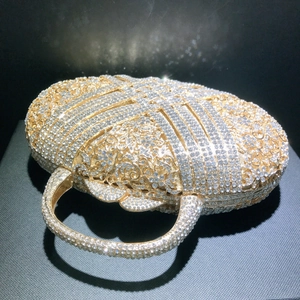 Golden rhinestone evening clutch with hollow floral carving and crystal round handle