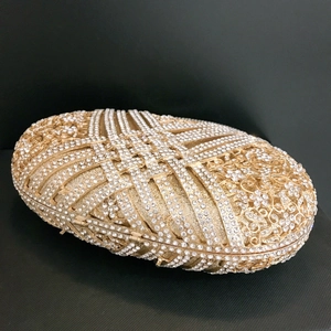 Luxurious gold oval clutch bag with hollow geometric metal patterns and sparkling rhinestones