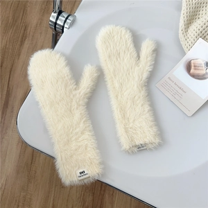 Detailed close-up of fluffy off-white plush mittens with a soft faux fur texture