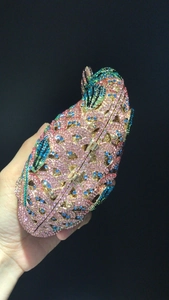 Pochette de soirée en forme d'oiseau ornée de strass colorés sur un fond noir élégant