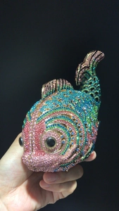 Détail de la pochette de soirée en forme de poisson avec des strass multicolores