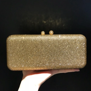 Detail of gold rhinestone evening clutch bag with sparkling stones and dual ball metal clasp