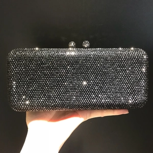 Macro detail of hand-held black evening clutch bag with sparkling crystals and silver locks