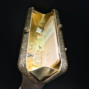 Detail view of gold rhinestone evening clutch showing interior capacity for a smartphone