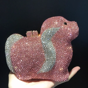 Gros plan sur la pochette de soirée en forme de chien rose ornée de strass étincelants