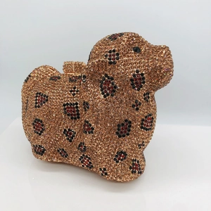 Vue détaillée du sac de soirée en forme de caniche serti de strass rouges et dorés
