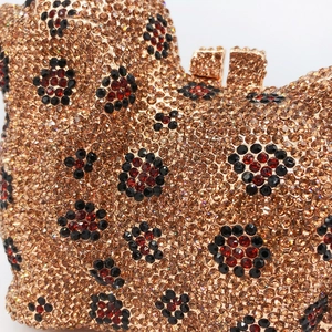 Détail macro d'une pochette de soirée dorée avec des motifs floraux en strass complexes