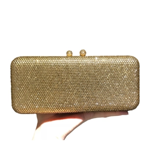 Elegant gold evening clutch bag covered in sparkling rhinestones with spherical clasps