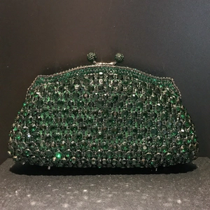 Macro shot of dark green crystal evening clutch with metallic frame and diamond closure