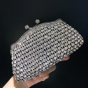 Close-up of luxury silver evening clutch bag with full rhinestone pavé and crystal ball clasp