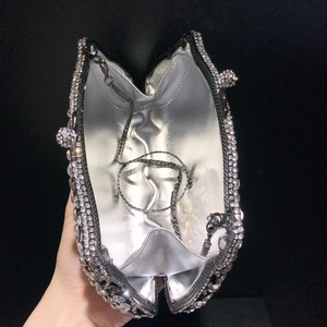 Macro detail of silver crystal evening clutch with metallic lining and chain strap