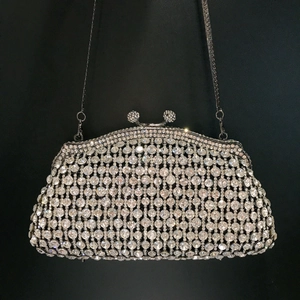 Detail of silver evening clutch bag featuring large round rhinestones and a jeweled clasp