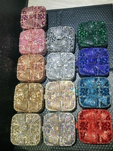 Flat lay of shimmering crystal clutch bags in various colors with bow rhinestone patterns