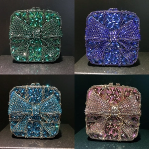 Detailed close-up of diamond clutches in emerald, blue, teal, and pink with rhinestone bows