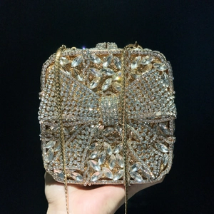 Macro shot of luxury evening clutch with sparkling diamond bow pattern and gold chain