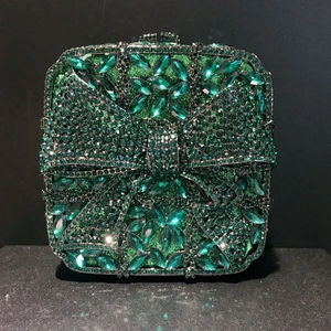 Detailed view of luxury square clutch with emerald green crystals and 3D rhinestone bow
