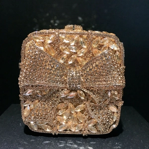 Macro detail of luxury champagne gold rhinestone clutch bag with a bow-shaped diamond design