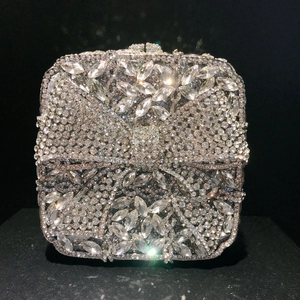 Close-up of luxury silver evening clutch with sparkling diamond bow knot pattern
