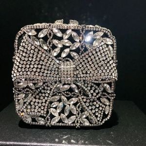 Close-up of a silver bow evening clutch featuring intricate crystal diamond flower patterns